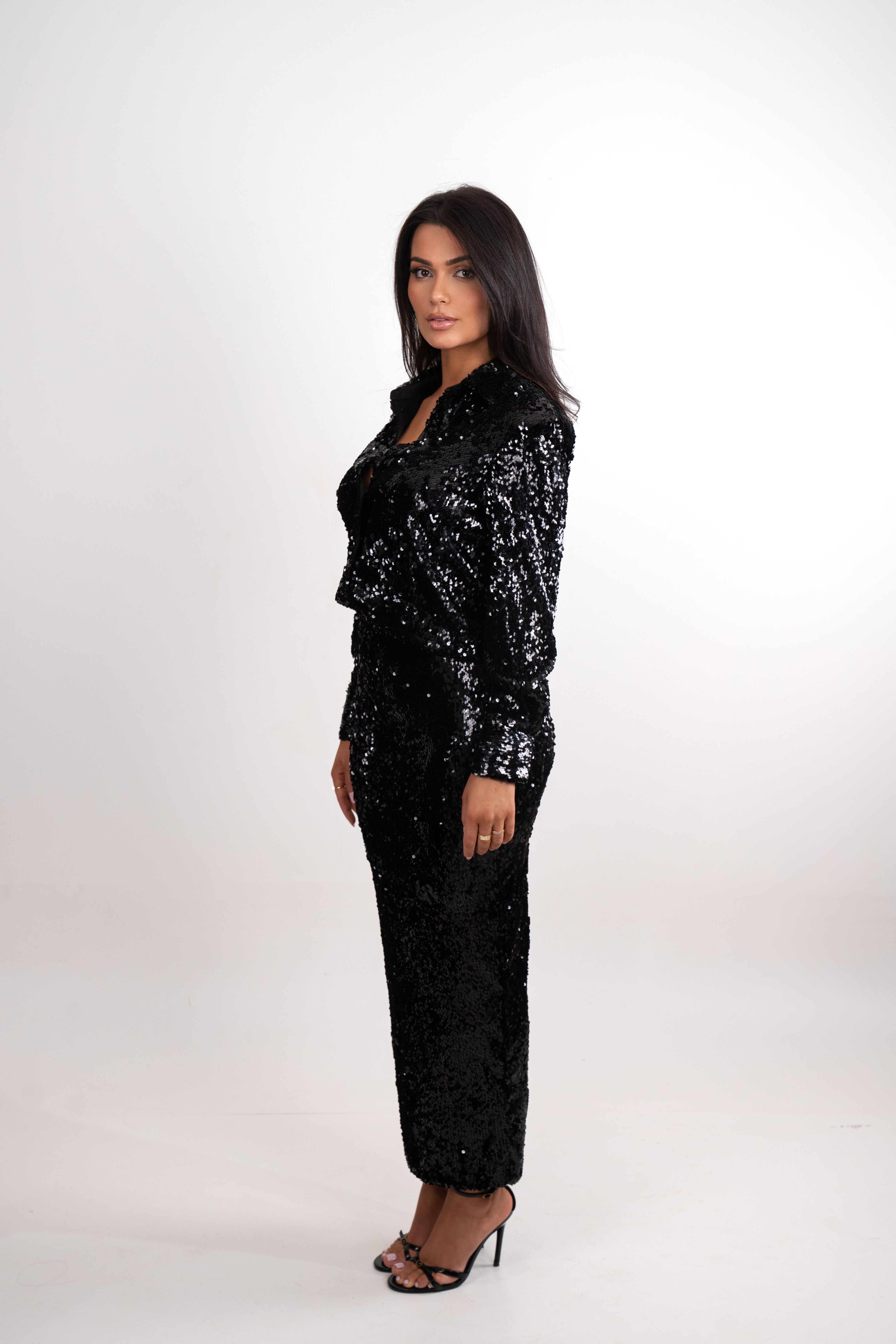 Woman wearing a black sequin outfit on a white background