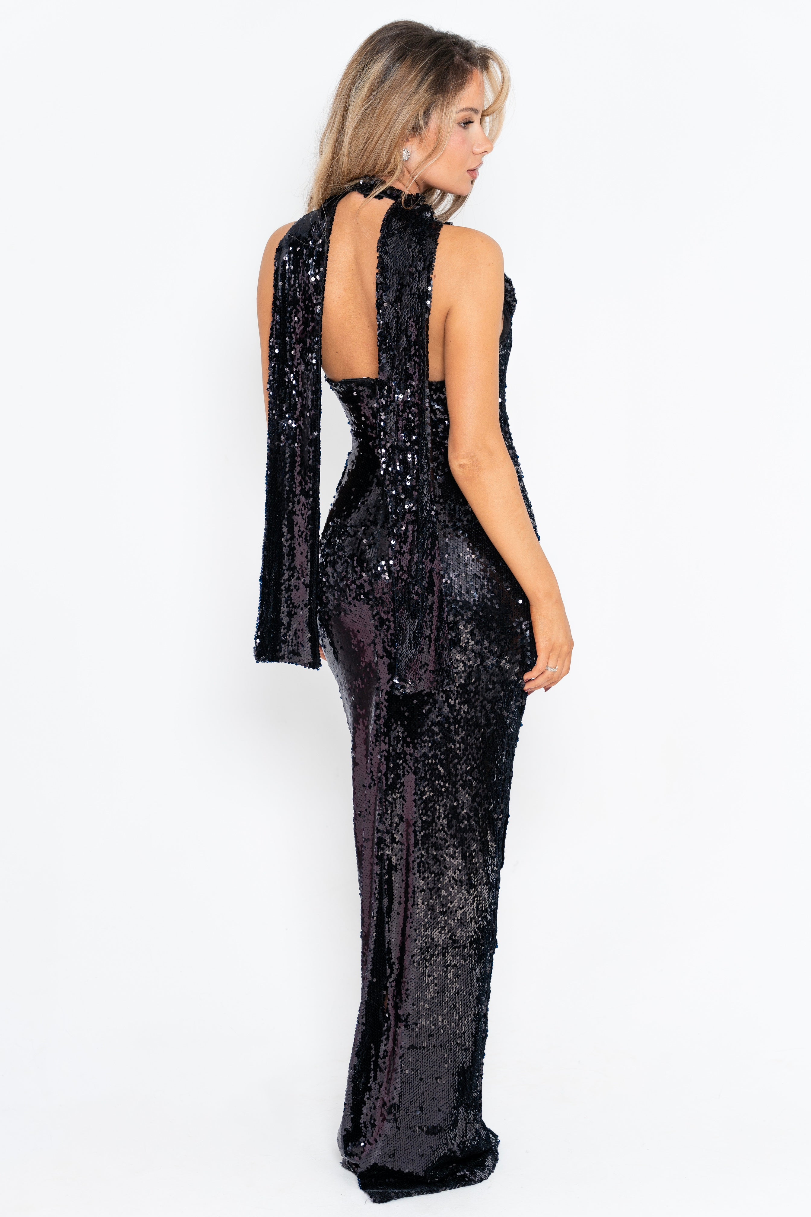 Chic black gown with dazzling sequins and a unique shoulder flower detail for a bold and elegant statement.