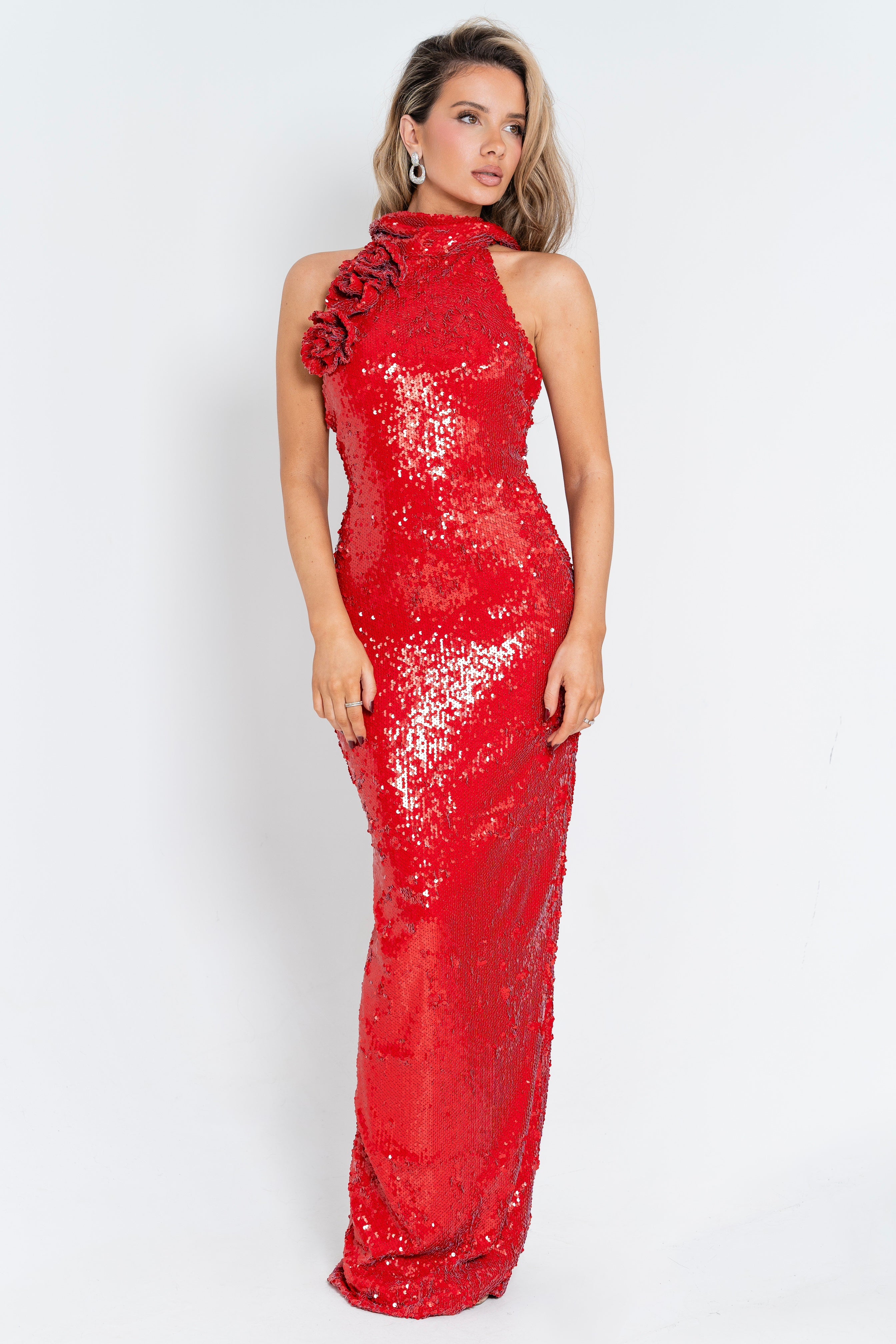 A captivating red sequin gown featuring a high neckline and floral shoulder detail, perfect for making a bold statement.