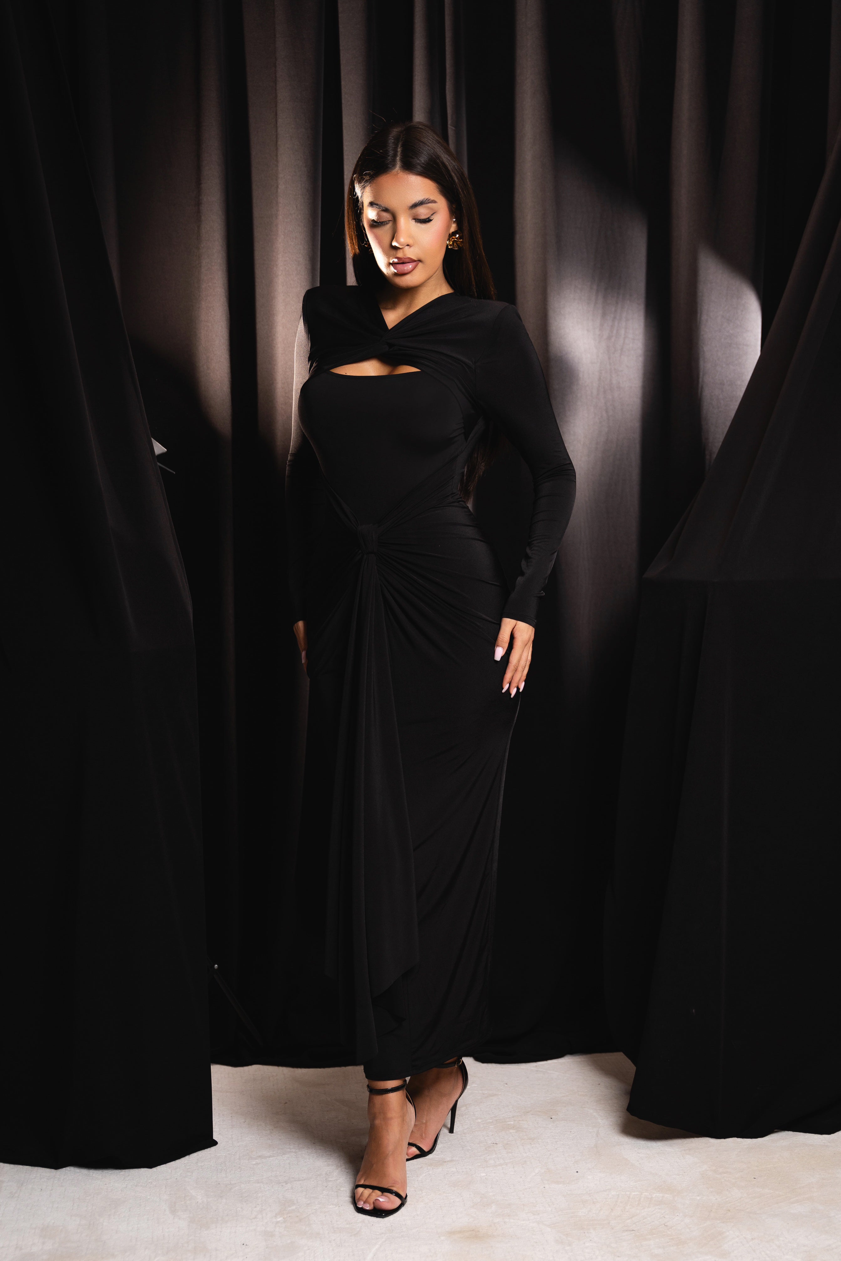 Striking black dress with a sculpted knot detail at the waist