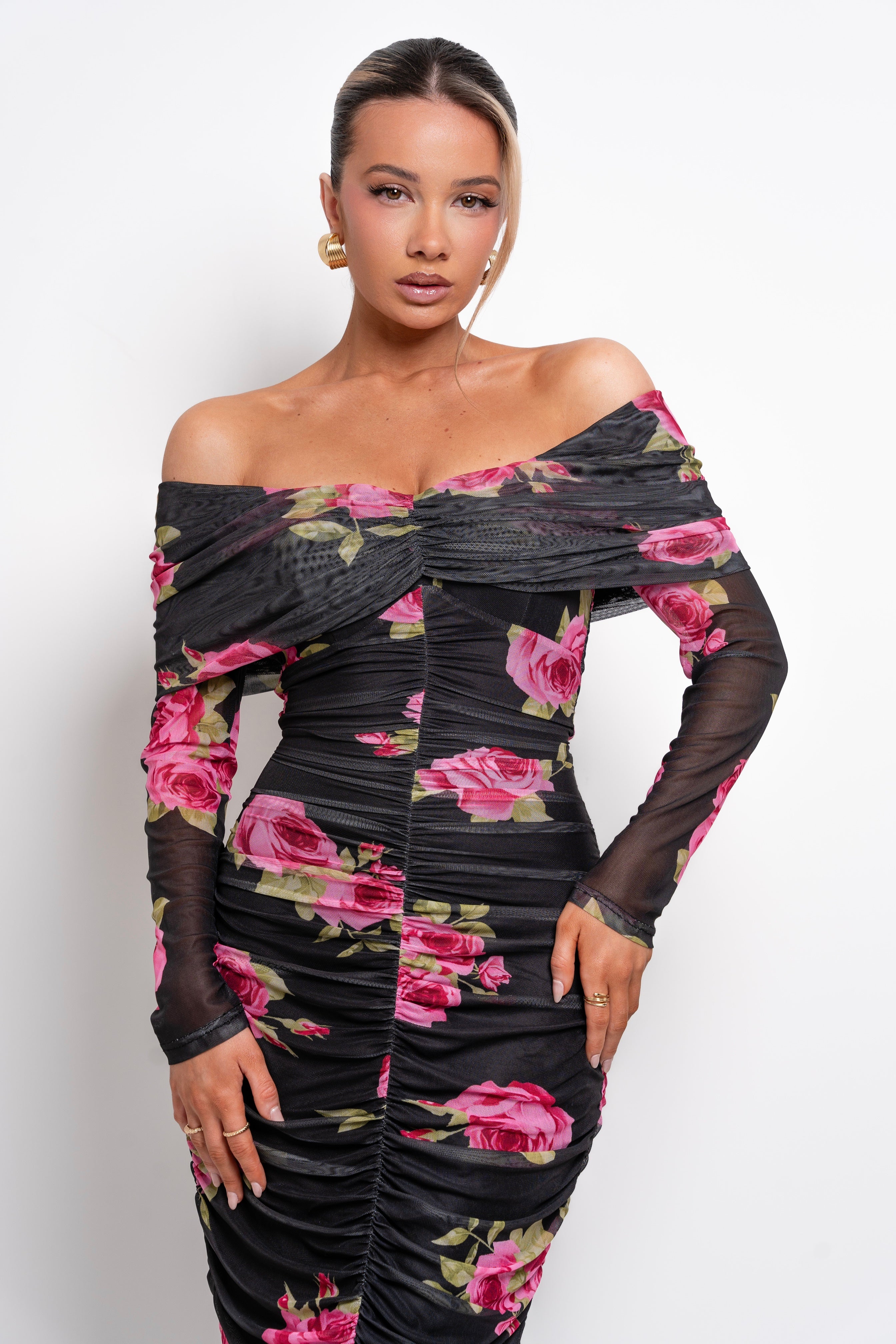 Glamorous off-shoulder floral gown with a curve-enhancing fit and dramatic detailing.