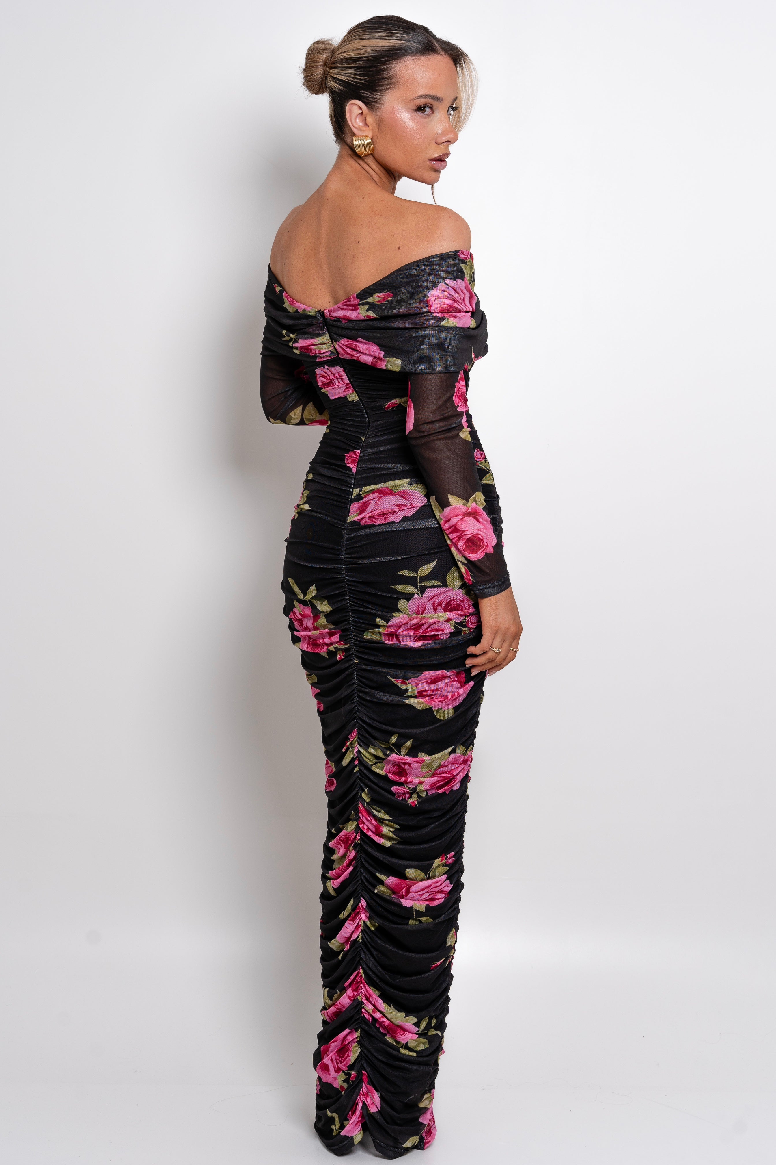 Romantic black and pink floral gown with a draped neckline and textured ruched fabric.