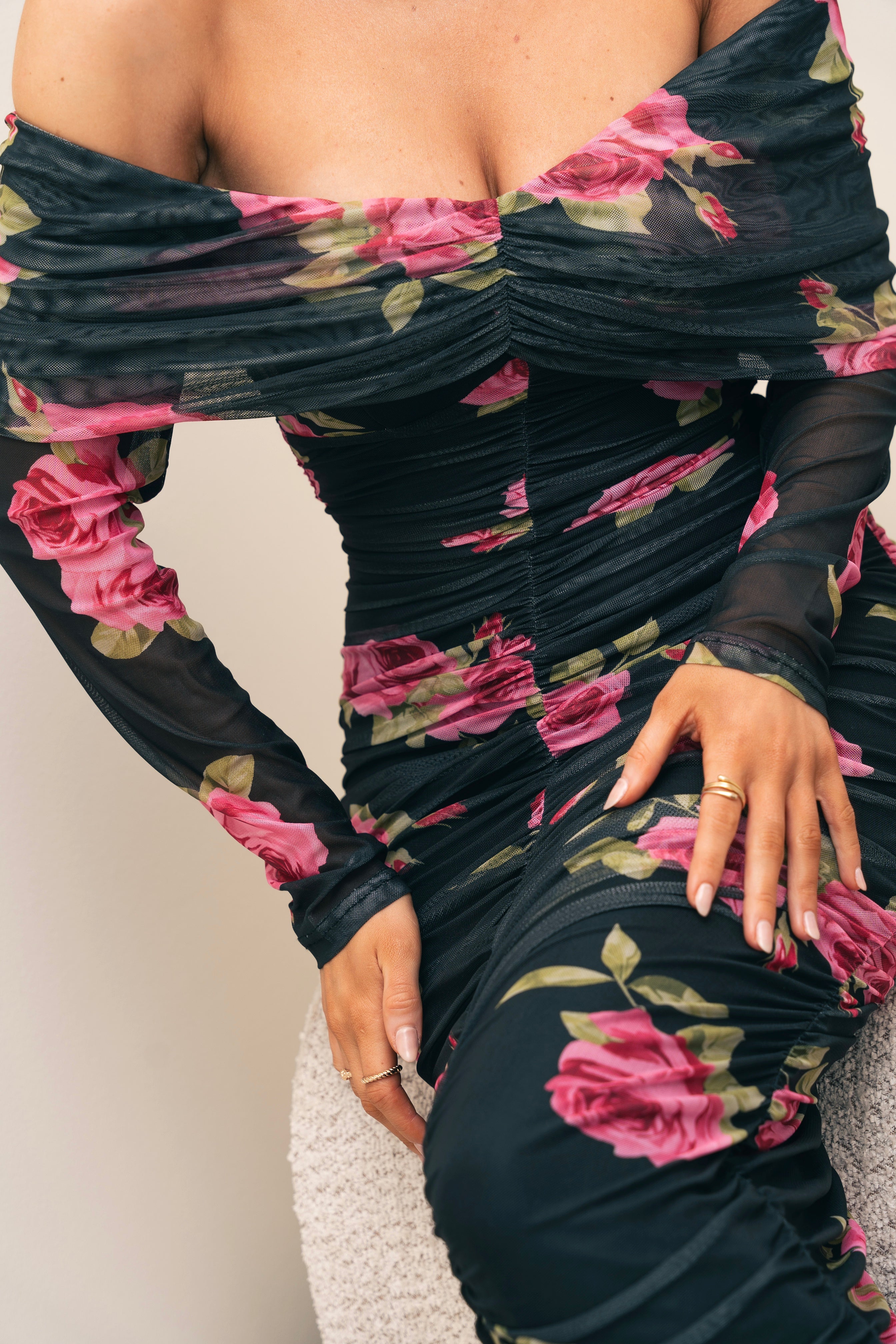 Modern floral maxi dress in black, featuring vivid rose prints and an elegant off-shoulder style.