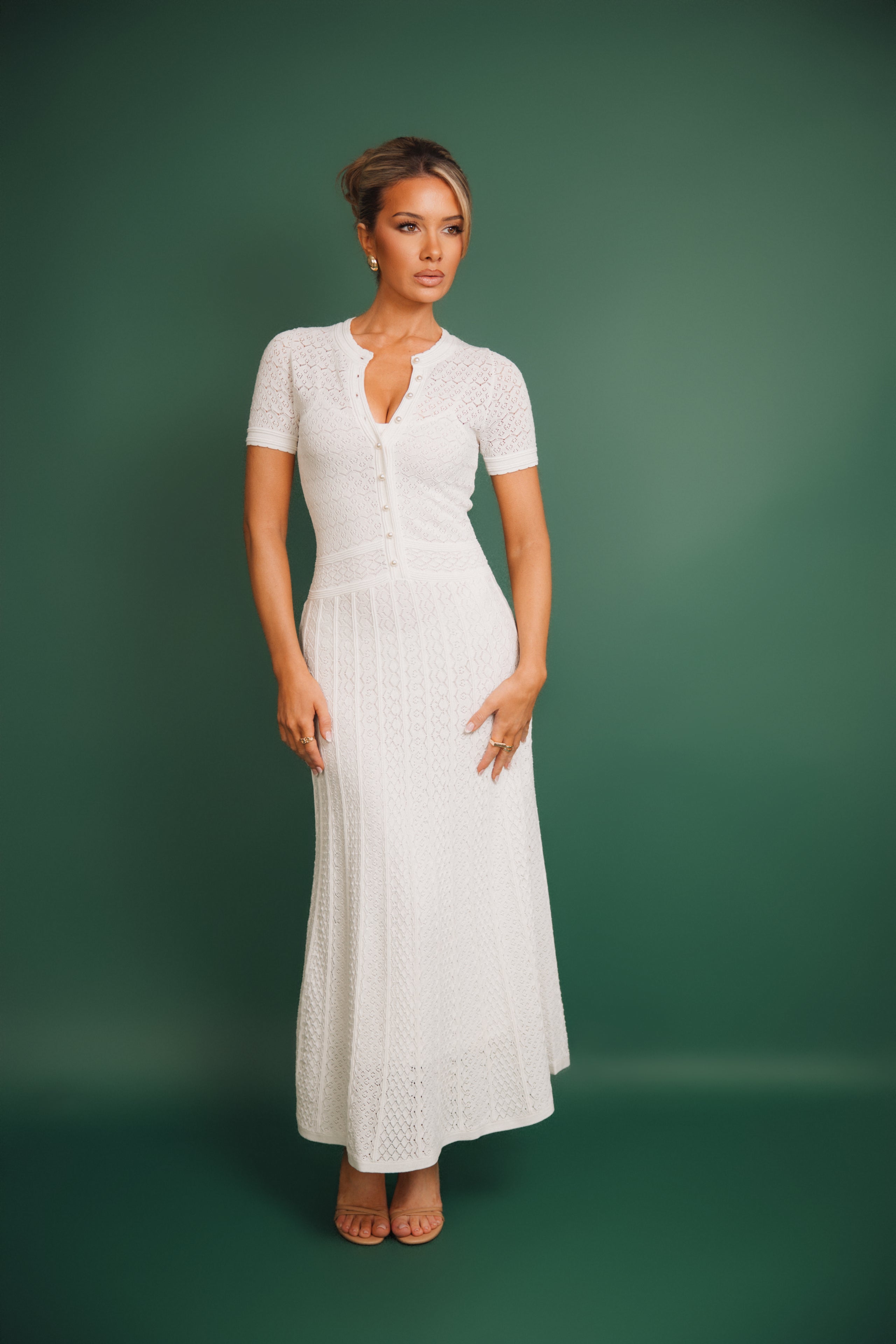 Woman wearing a white dress with a green background