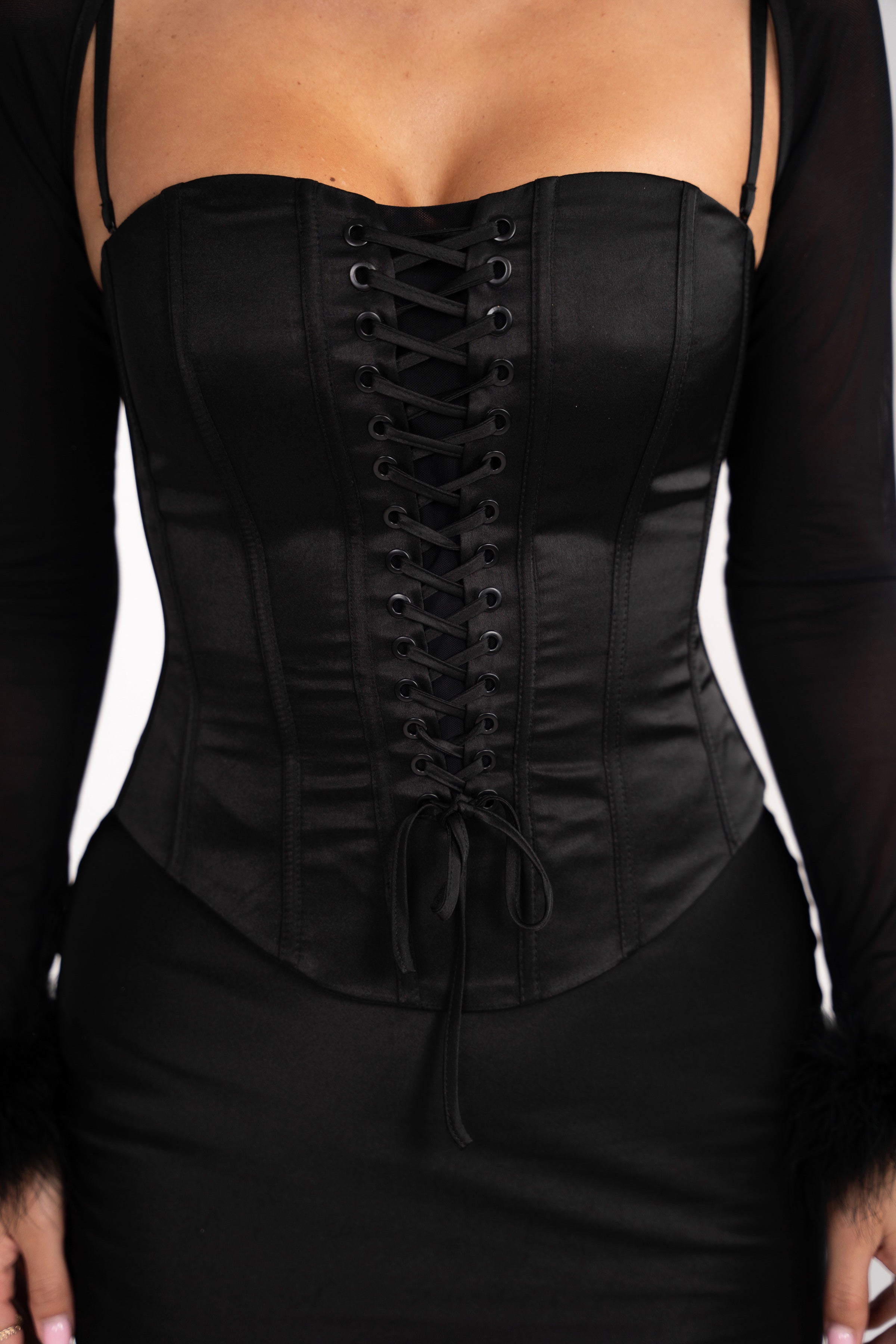 Detailed shot of the feathered sleeves on the mesh bolero, adding a dramatic and textured contrast to the Stela dress.