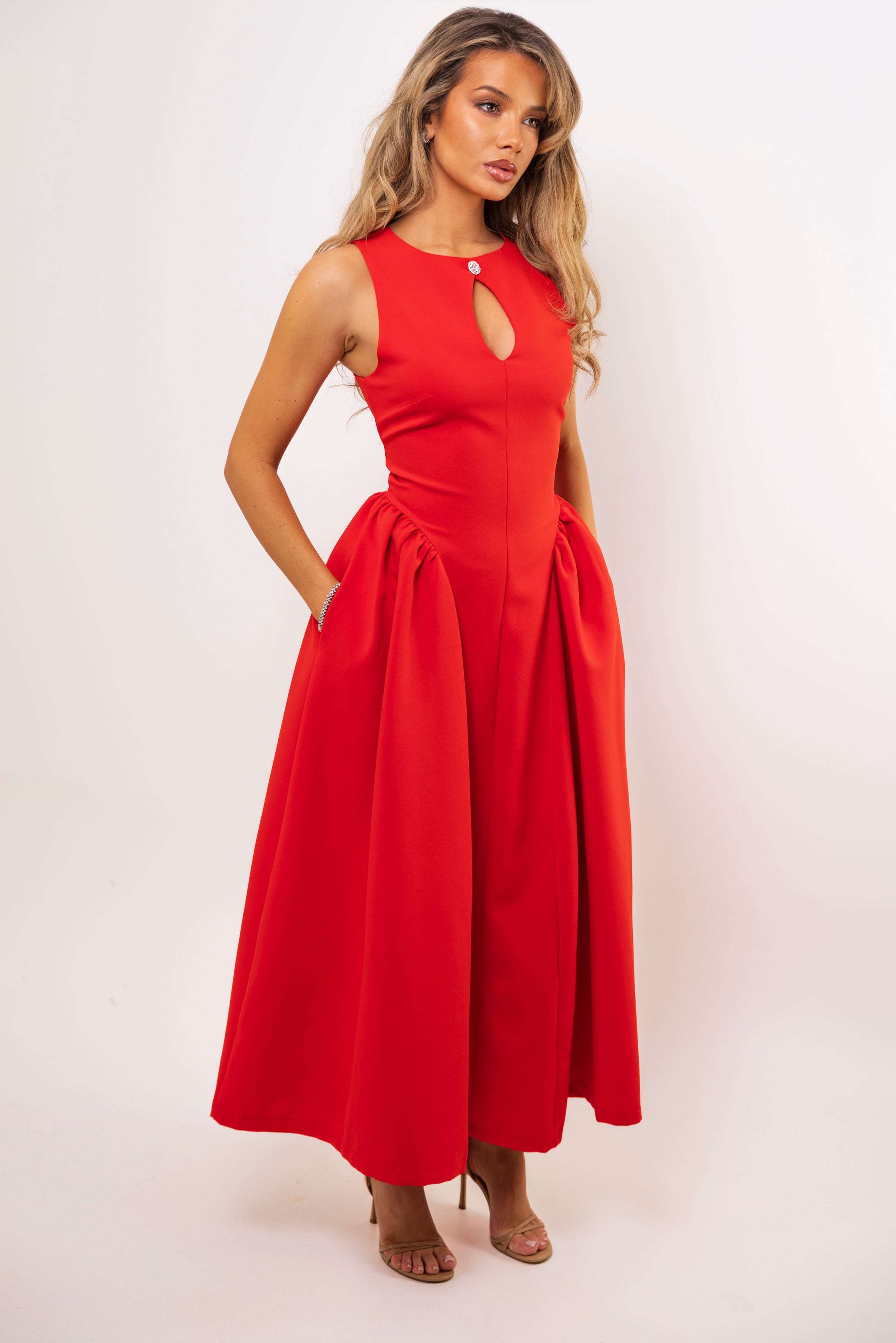 Woman wearing a red dress with a cutout design on a white background