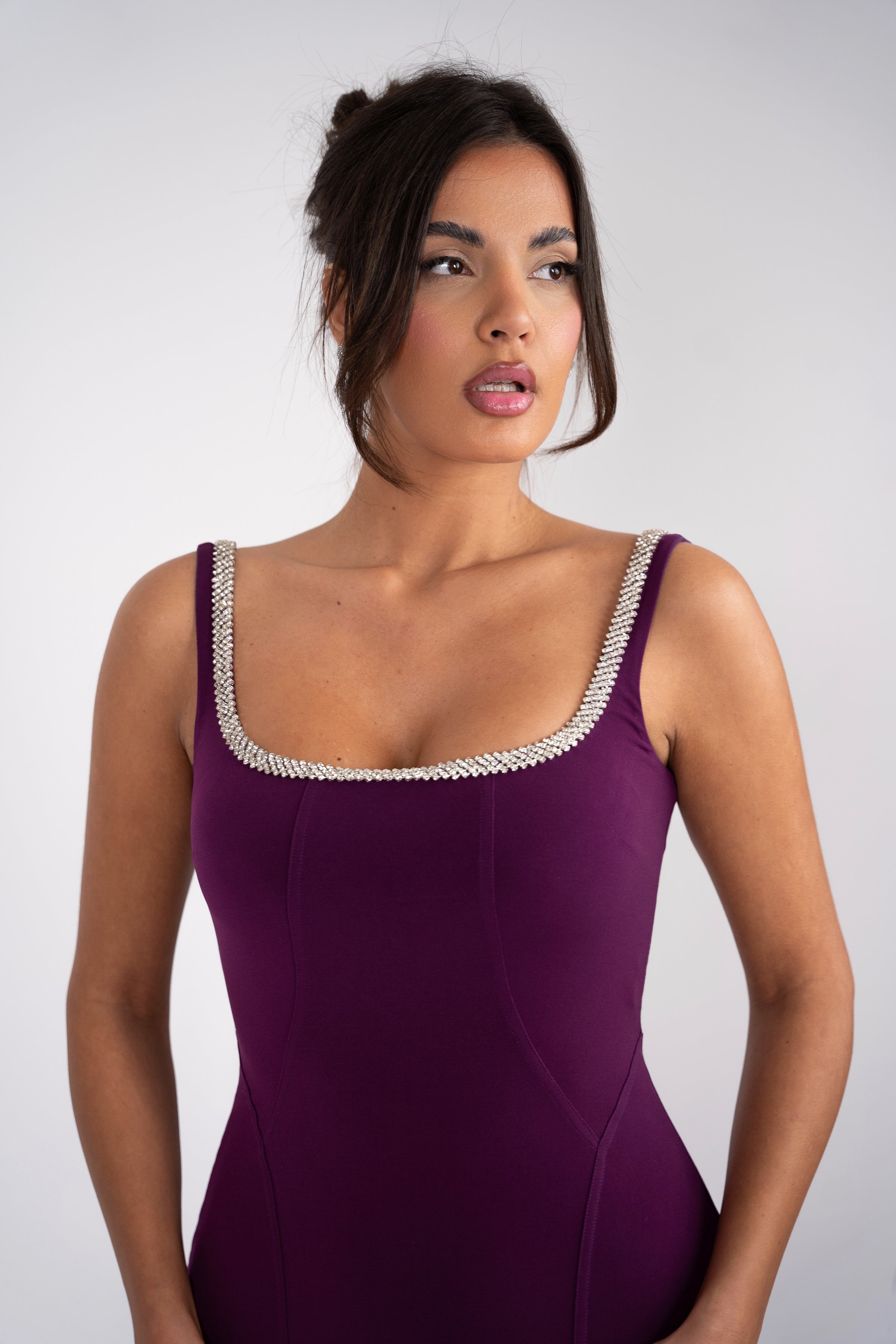 Close-up of a sleek purple evening gown with sparkly trim.