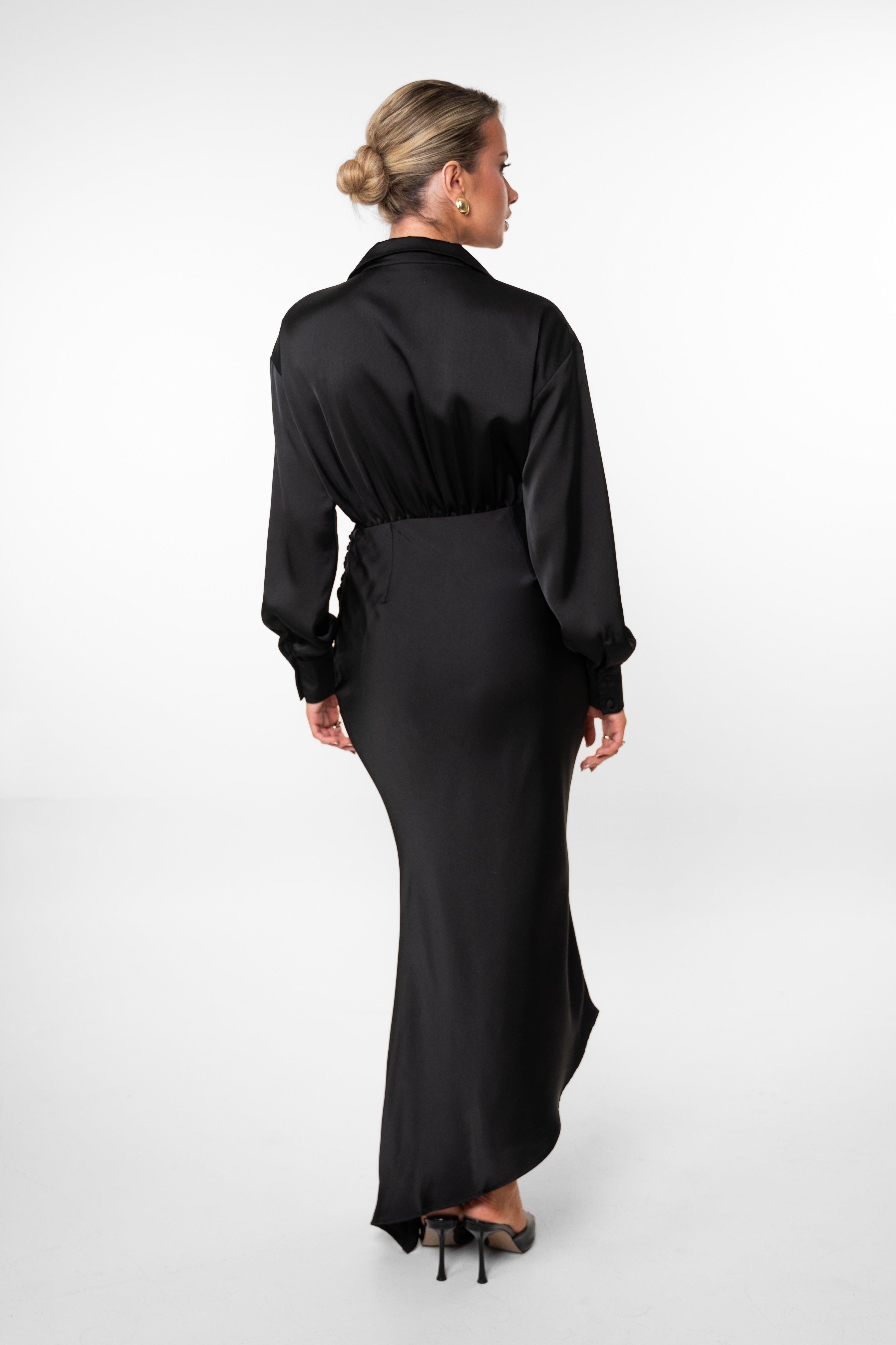 Woman wearing a black dress with a belt on a white background