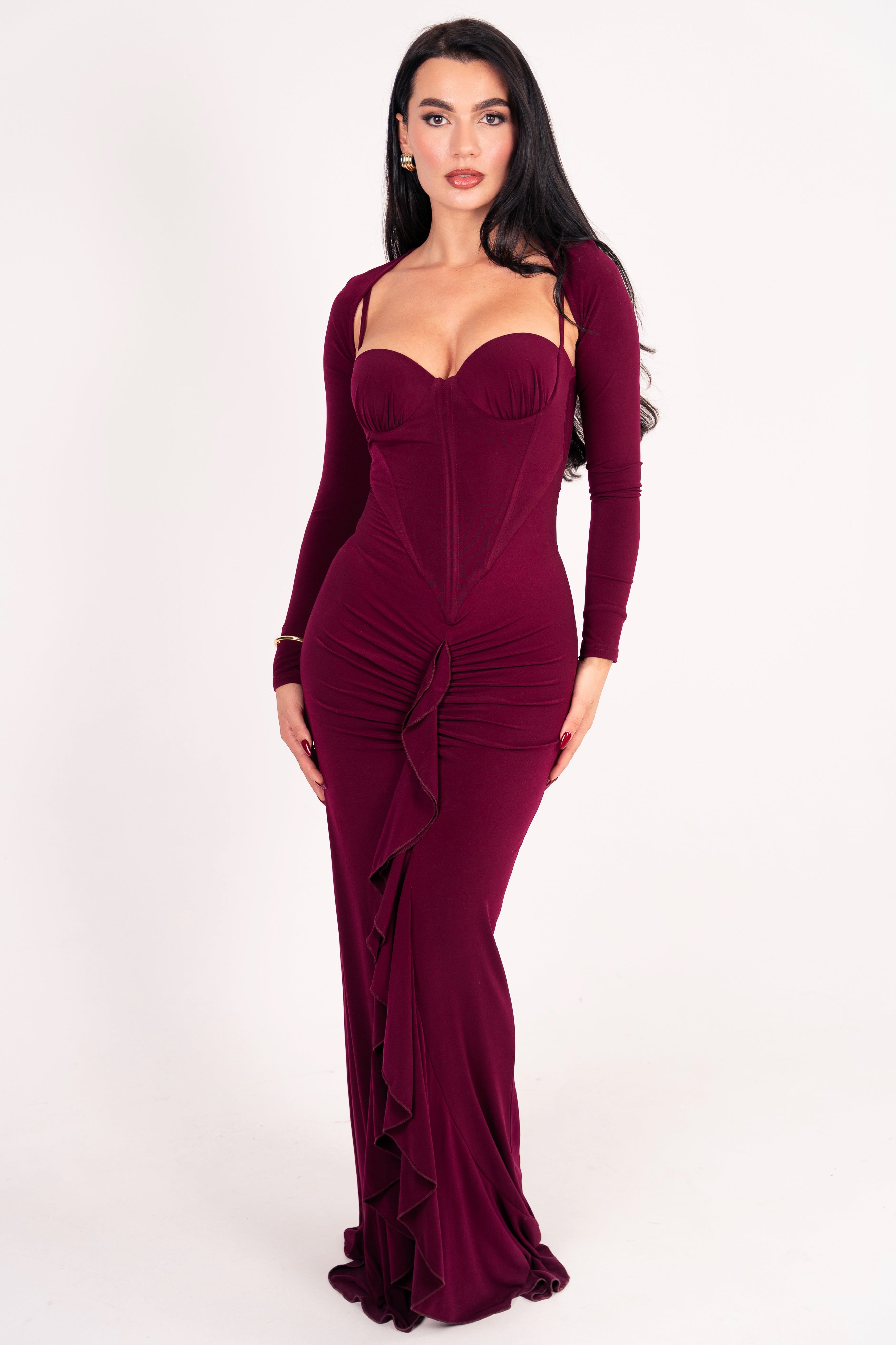 Body-hugging evening gown with structured top and long sleeves.