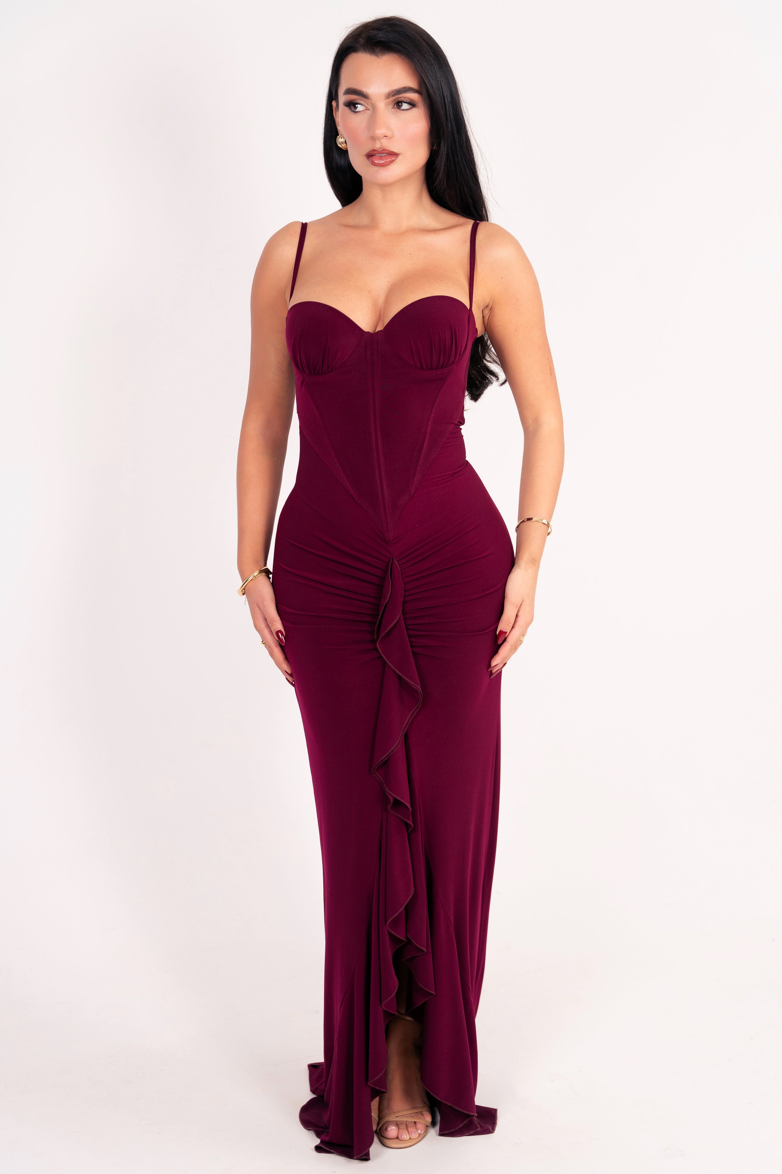 Long burgundy evening dress with dramatic ruffle detail and form-fitting design.





